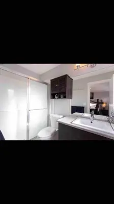 a bathroom with a sink and a toilet and a mirror at Cheerful and beautiful 3 bedroom home close lake in Edmonton