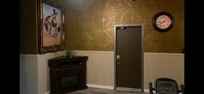 a room with a door and a clock on the wall at Coldwater Hotel in Merritt