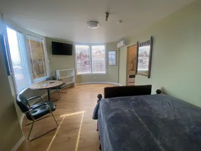 a bedroom with a bed and a table and chairs at Coldwater Hotel in Merritt