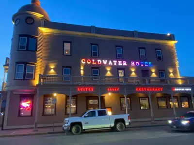 a white truck parked in front of a building at Coldwater Hotel in Merritt