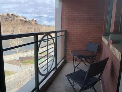 a balcony with two chairs and a table and a window at Amicable, Cozy, High Speed Internet, Sleeps 2 Riverview Downtown Apartment in Calgary
