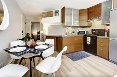 a kitchen with a table and white chairs in a room at Gondola Haus - Free parking in Whistler