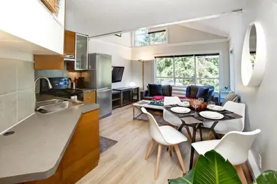 a kitchen and living room with a table and chairs at Gondola Haus - Free parking in Whistler