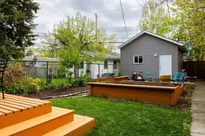 a backyard with a hot tub in the grass at Trendy Kensington 3 min Walk Backyard AC Garage in Calgary