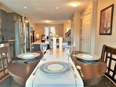a kitchen with a wooden table with wine glasses at Stylish Getaway by Spruce Meadows in Calgary