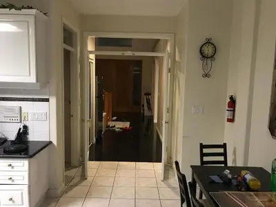 a kitchen with a dining table and a kitchen with a clock at Xin Xin House in Richmond