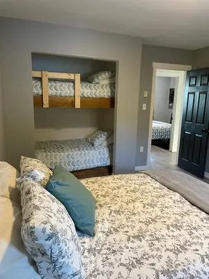a bedroom with two bunk beds and a rug at Sunrise Mountain view Skidegate House in Skidegate