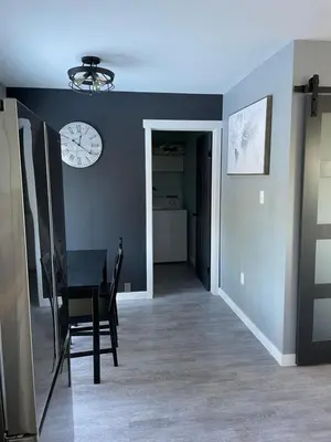 a dining room with a table and a clock on the wall at Sunrise Mountain view Skidegate House in Skidegate