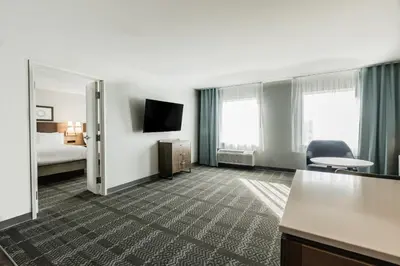 a hotel room with a bed and a mirror at Staybridge Suites - Dawson Creek by IHG in Dawson Creek