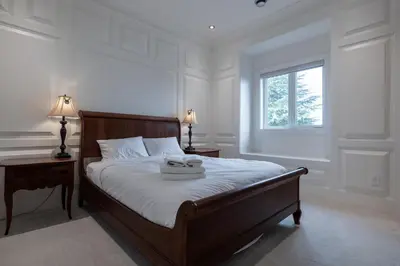 a bedroom with a bed with two tables and a window at Luxurious Private Rooms in Richmond in Richmond