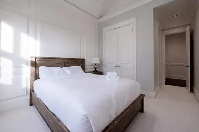 a white bedroom with a large bed with white sheets at Luxurious Private Rooms in Richmond in Richmond