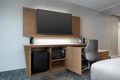 a room with a desk with a tv and a chair at Courtyard by Marriott Nanaimo in Nanaimo