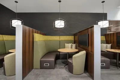 a restaurant with tables and chairs and a tv at Courtyard by Marriott Nanaimo in Nanaimo