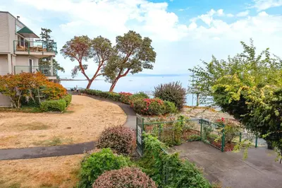 a walkway leading to a house with flowers and plants at Sunrise Cove Apt at Inn of The Sea in Ladysmith