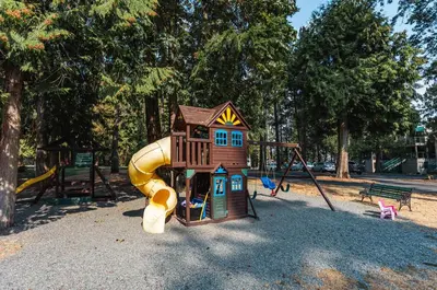 a playground with a small house and a slide at Sunrise Cove Apt at Inn of The Sea in Ladysmith