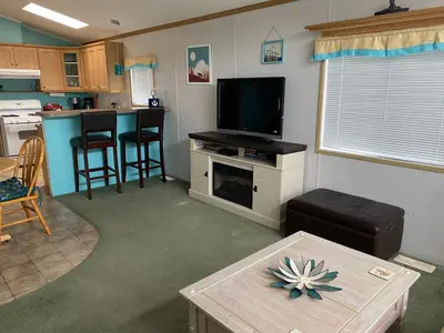 a living room with a television and a table at Beaver Lake Resort Site #36 in Lake Cowichan