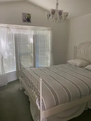 a white bed in a bedroom with a window at Beaver Lake Resort Site #36 in Lake Cowichan