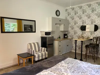 a bedroom with a bed and a kitchen with a table at Battle Creek Ranch, Wells Gray Park in Clearwater