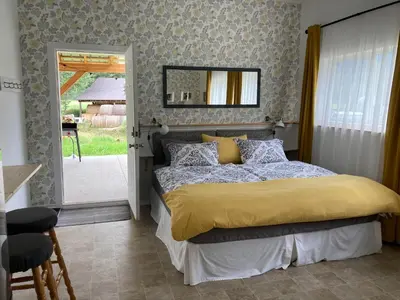 a bedroom with a bed with a yellow comforter at Battle Creek Ranch, Wells Gray Park in Clearwater