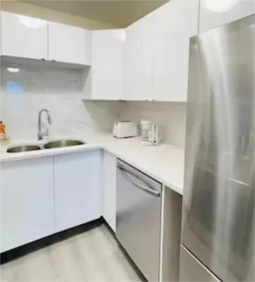 a white kitchen with a sink and a refrigerator at unit #301 Mountain view 2BR in Canmore Down town in Canmore