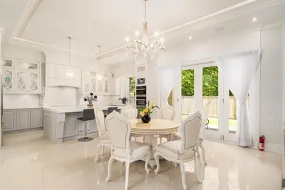 a white kitchen with a table and chairs at Vancouver Shangrila House in Richmond