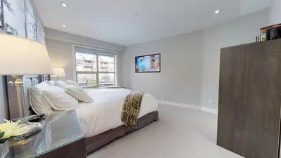 a white bedroom with a bed and a window at 260 The Aspens - Ski In Ski Out in Whistler