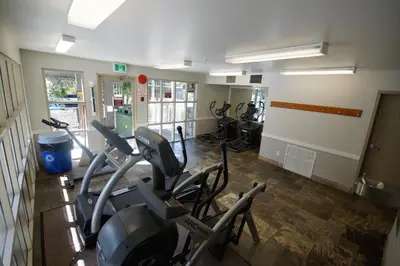 a gym with treadmills and ellipticals in a room at 260 The Aspens - Ski In Ski Out in Whistler