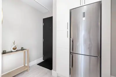 a stainless steel refrigerator in a white room at Modern & Stylish 1-Bedroom Unit in Edmonton