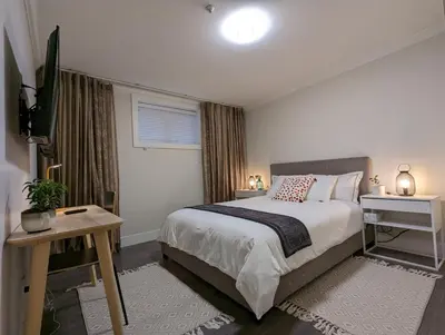 a bedroom with a bed and a television in it at Nice home away at Vancouver near YVR in Vancouver