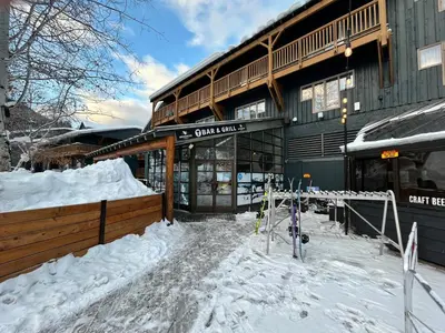 a snow covered building with skis in front of it at Perfect Ski or Bike in-out Hot Tub Pool in Panorama