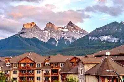 a view of a hotel with mountains in the background at Falcon Crest Lodge 1 BR Condo With Gym & Hot-Tubs & Mountain View in Canmore