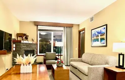 a living room with a couch and a fireplace at Falcon Crest Lodge 1 BR Condo With Gym & Hot-Tubs & Mountain View in Canmore