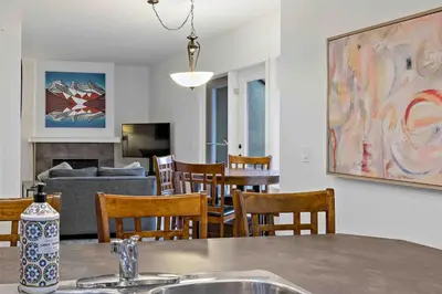 a kitchen and living room with a table and chairs at Mountain Retreat - Modern and Bright with Panorama Views 2 bedrooms, 4 beds, heated all-year outdoor pool, hottub, balcony, Banff Park Pass in Canmore