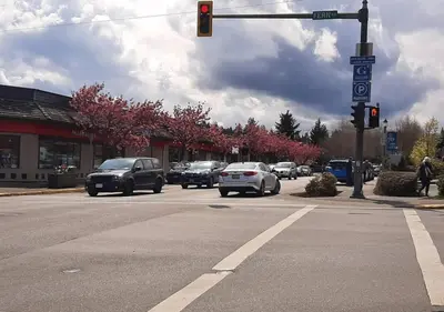 a traffic light at an intersection with cars on a street at Oceanside Manor - Golf Course View in Qualicum Beach