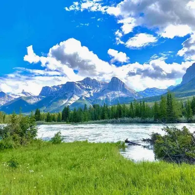 a view of a river with mountains in the background at Wanna get away next Summer and Fall at the Crossing in Canmore