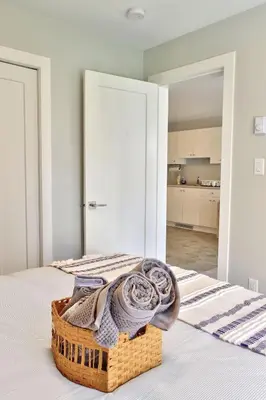 a bedroom with a basket on a bed at Zen Retreat Langford in Victoria