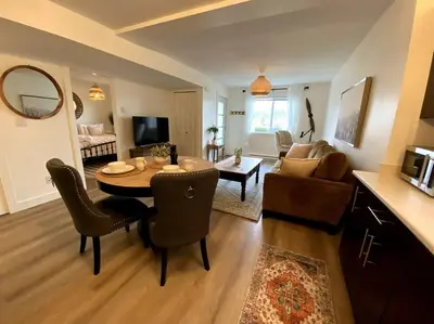 a living room with a table and chairs and a living room at Cozy Lakeview Suite in Victoria