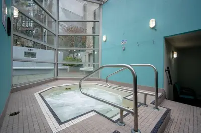 a hot tub with a hand rail in a building at Heart of Downtown King Suite/Parkng/Pool/Gym/Sauna in Vancouver