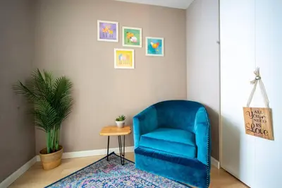 a blue chair sitting in a room with a rug at Heart of Downtown King Suite/Parkng/Pool/Gym/Sauna in Vancouver