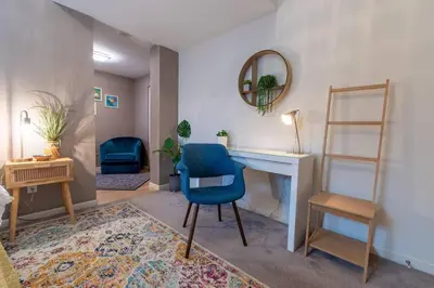 a living room with a blue chair and a desk at Heart of Downtown King Suite/Parkng/Pool/Gym/Sauna in Vancouver