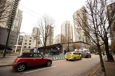 a red car and a yellow car on a city street at Heart of Downtown King Suite/Parkng/Pool/Gym/Sauna in Vancouver
