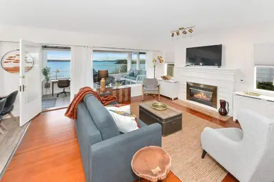 a living room with a blue couch and a fireplace at The Beach House Suite by EMR Vacation Rentals in Chemainus