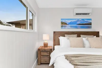 a bedroom with a large bed and a window at The Beach House Suite by EMR Vacation Rentals in Chemainus