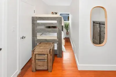 a room with a bunk bed and a table and a mirror at The Beach House Suite by EMR Vacation Rentals in Chemainus