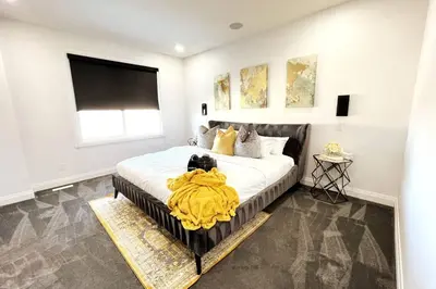 a bedroom with a large bed with a yellow blanket on it at Stunning 3BR Luxury Home N/Edm*2 king beds* in Edmonton