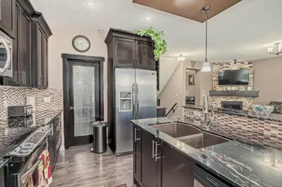 a kitchen with a stainless steel refrigerator at Luxury 4 Bedroom Cozy Home close to YYC, Shops, DT, Stampede, Mountains and many amenities in Panorama Hills NW Calgary in Calgary