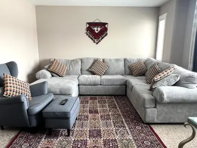 a living room with a couch and a chair at Luxury 4 Bedroom Cozy Home close to YYC, Shops, DT, Stampede, Mountains and many amenities in Panorama Hills NW Calgary in Calgary