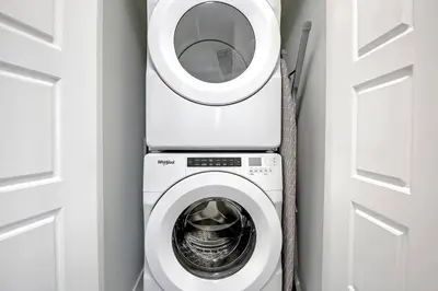 a washer and dryer in a room next to a door at Beautiful 3Bed-with AC-Close to Spruce Meadows & Mountains in Calgary