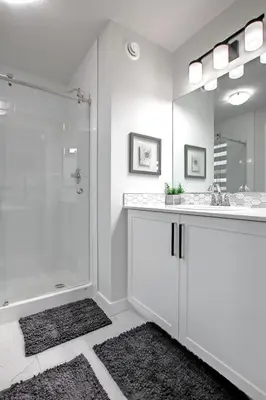 a white bathroom with a shower and a sink at Beautiful 3Bed-with AC-Close to Spruce Meadows & Mountains in Calgary