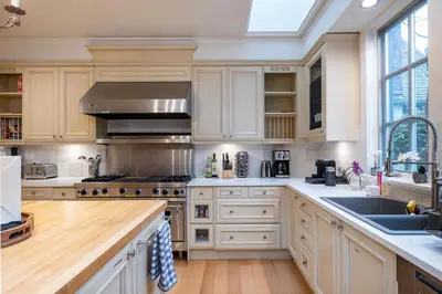 a kitchen with white cabinets and a sink at Vancouver Golf Villa - Private Oasis in Vancouver